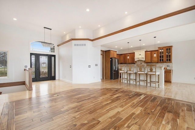 unfurnished living room with light wood-style flooring, visible vents, baseboards, and recessed lighting