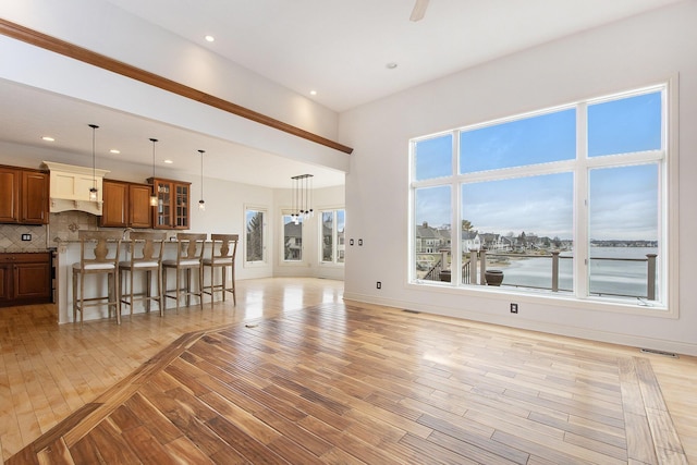 unfurnished living room with light wood finished floors, baseboards, and recessed lighting