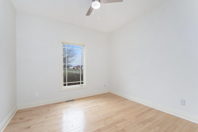 spare room with light wood-style floors, baseboards, visible vents, and a ceiling fan