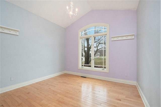 empty room with light wood finished floors, baseboards, visible vents, an inviting chandelier, and vaulted ceiling