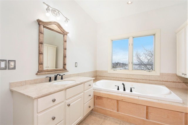 full bath featuring a garden tub, vanity, and tile patterned floors