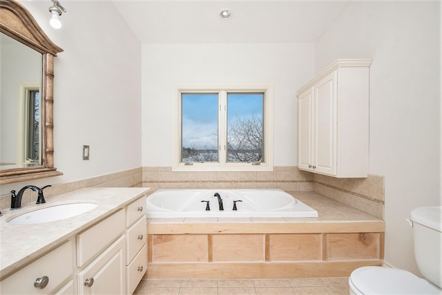 full bathroom featuring a bath, vanity, toilet, and tile patterned floors