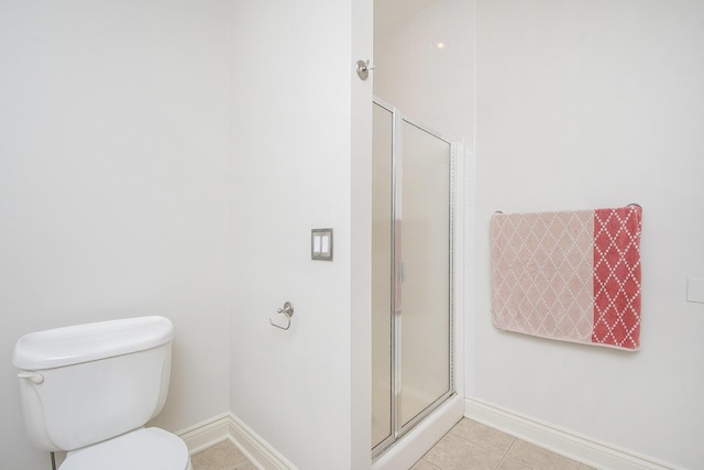 bathroom featuring tile patterned flooring, baseboards, a shower stall, and toilet