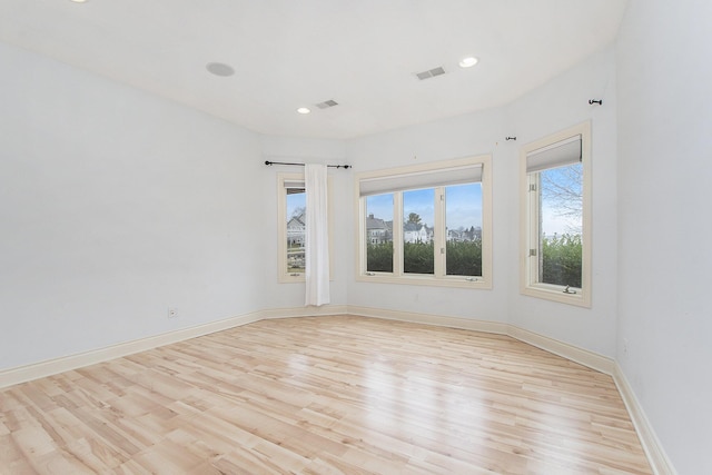 empty room featuring recessed lighting, baseboards, visible vents, and light wood finished floors