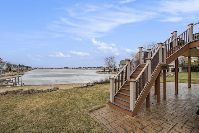 view of yard with a water view, a patio, and stairway