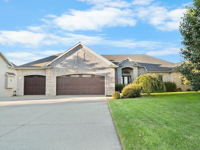 view of front of property featuring an attached garage, brick siding, concrete driveway, and a front yard