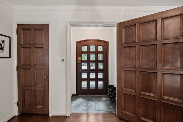 entrance foyer with baseboards, arched walkways, and dark wood-style floors