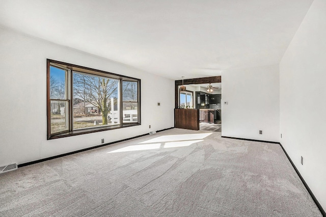 empty room with visible vents, baseboards, and carpet