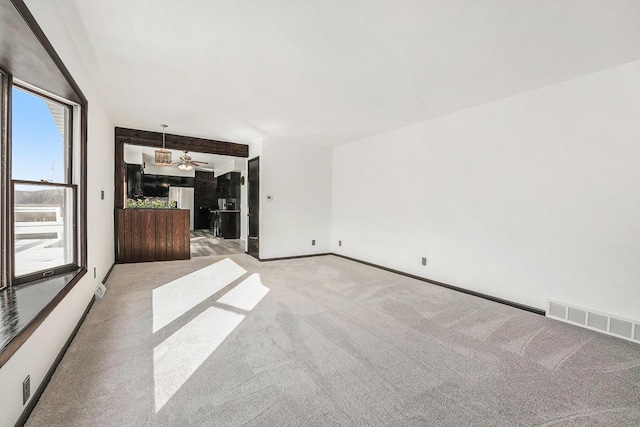 spare room with baseboards, visible vents, and light carpet