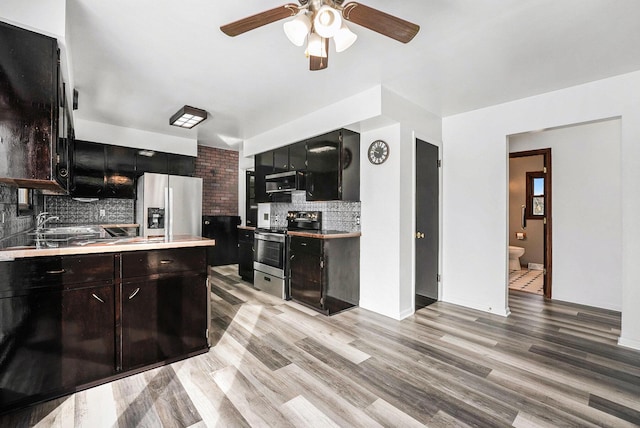 kitchen with ceiling fan, stainless steel appliances, light countertops, light wood-style floors, and tasteful backsplash