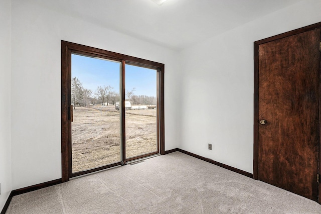 unfurnished room featuring baseboards and light carpet