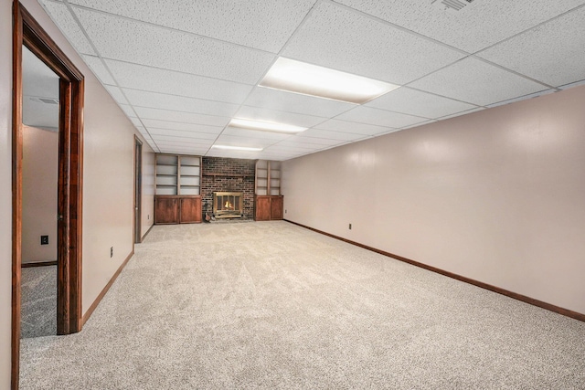 finished below grade area with baseboards, a fireplace, and carpet flooring