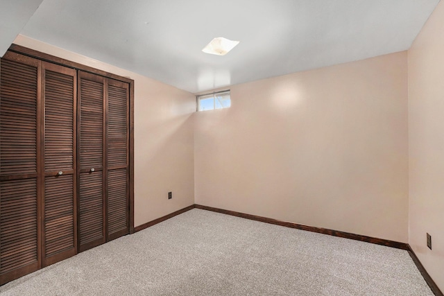 unfurnished bedroom featuring a closet, baseboards, and carpet