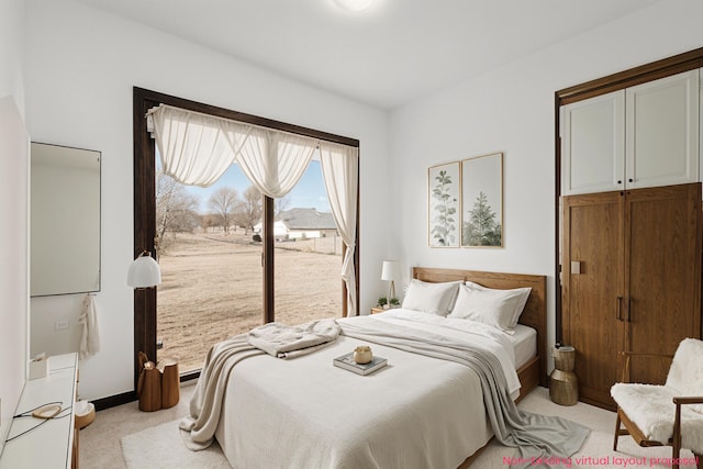 bedroom with light colored carpet, baseboards, and access to outside