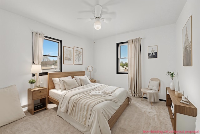 bedroom featuring baseboards, light colored carpet, and a ceiling fan