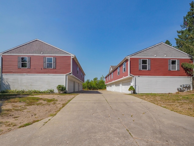 view of property exterior with a garage and concrete driveway