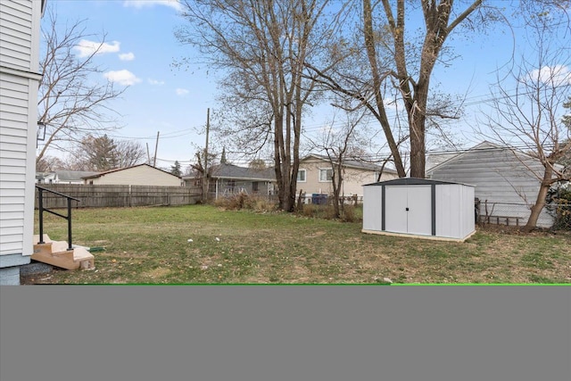 view of yard featuring a storage shed, an outdoor structure, and a fenced backyard