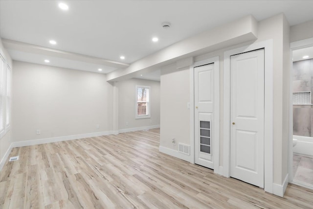 below grade area featuring recessed lighting, light wood-type flooring, visible vents, and baseboards