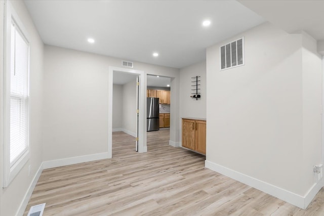 unfurnished room with baseboards, visible vents, and light wood finished floors