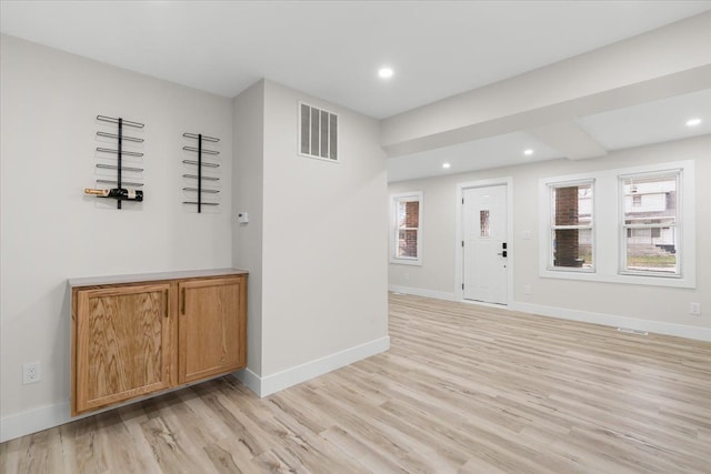 foyer featuring light wood-type flooring, baseboards, visible vents, and recessed lighting