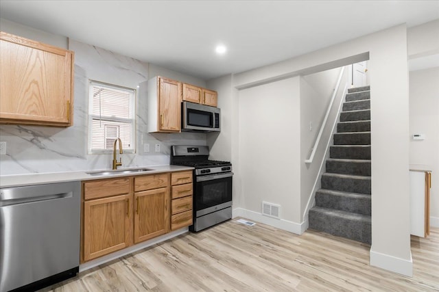 kitchen with visible vents, stainless steel appliances, a sink, and light countertops