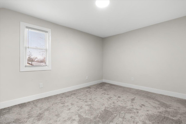 carpeted empty room with baseboards