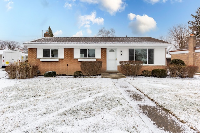 single story home featuring brick siding and a chimney