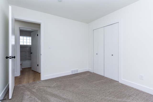 unfurnished bedroom featuring a closet, carpet, visible vents, and baseboards