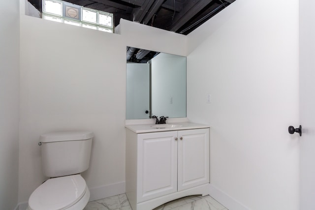 half bathroom with marble finish floor, vanity, toilet, and baseboards