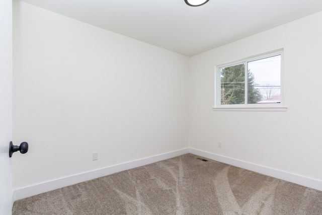 unfurnished room with carpet and baseboards