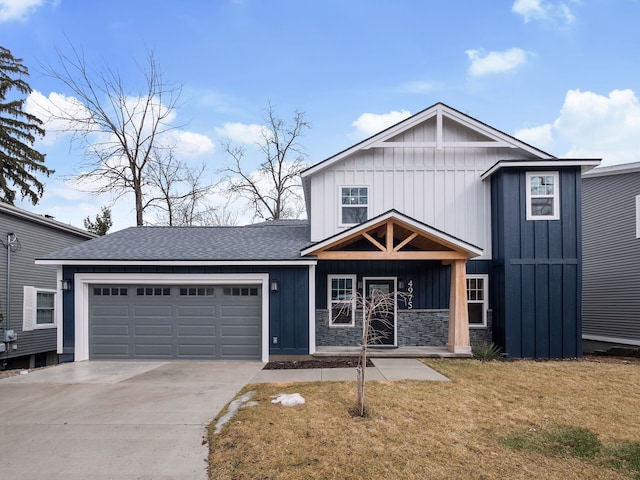 view of front of house with a garage, driveway, roof with shingles, board and batten siding, and a front yard