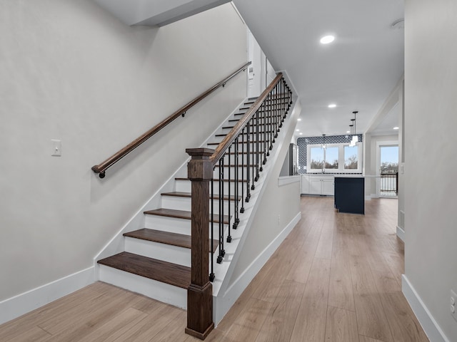 stairway with recessed lighting, baseboards, and wood finished floors