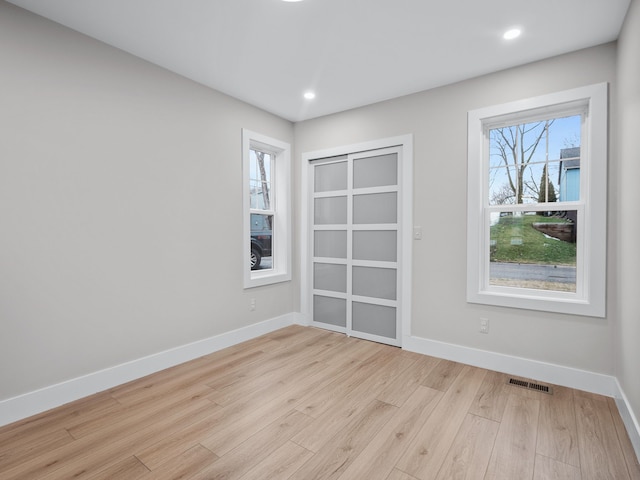 empty room with recessed lighting, visible vents, baseboards, and wood finished floors