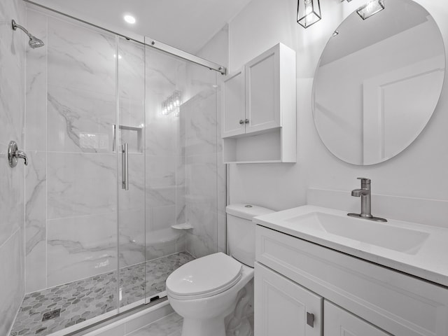 full bath with a marble finish shower, vanity, and toilet