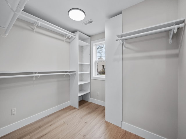 walk in closet with wood finished floors and visible vents