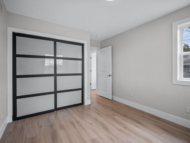 unfurnished bedroom with baseboards, visible vents, and light wood-style floors