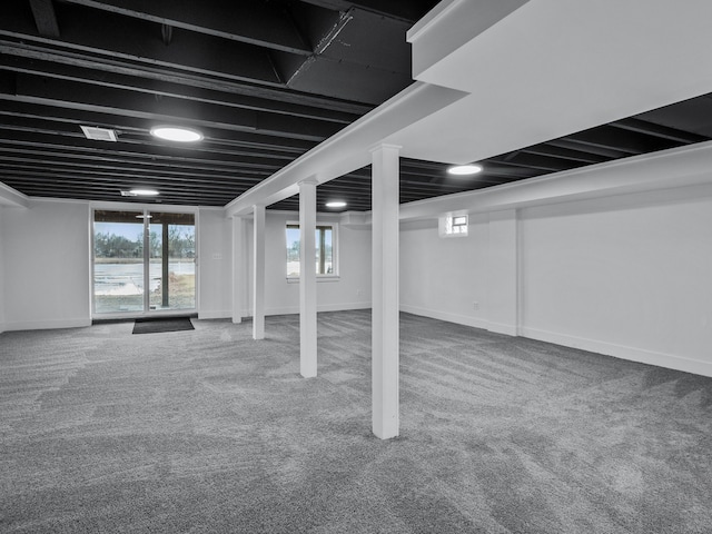 below grade area with carpet floors, visible vents, and baseboards