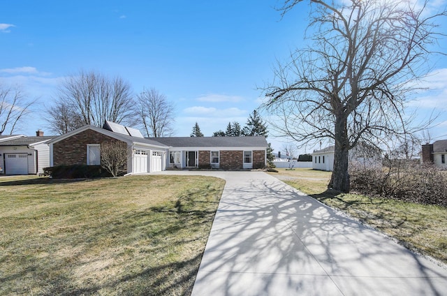 view of front of home with brick siding, an attached garage, driveway, and a front yard