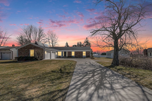 view of front facade with a front lawn, a garage, and driveway