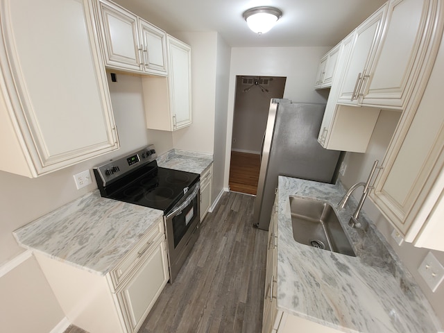 kitchen featuring stainless steel appliances, dark wood-style flooring, a sink, baseboards, and light stone countertops