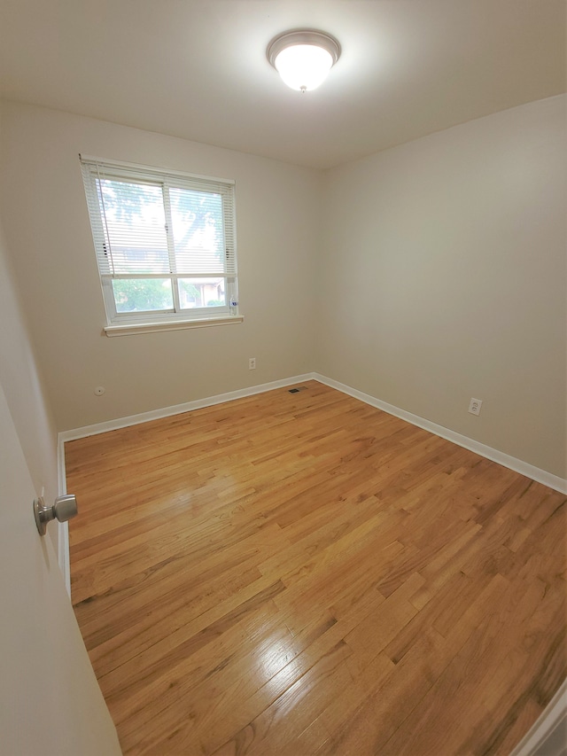 unfurnished room with light wood finished floors and baseboards