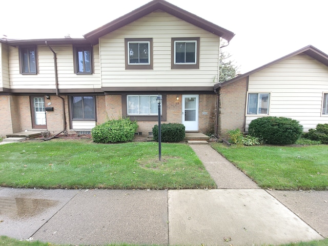 multi unit property featuring crawl space, brick siding, and a front lawn