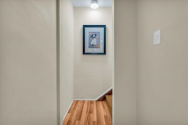 corridor featuring wood finished floors and baseboards