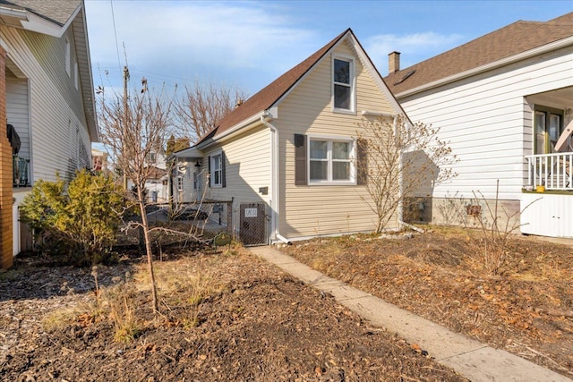 view of side of property featuring central AC unit and a gate