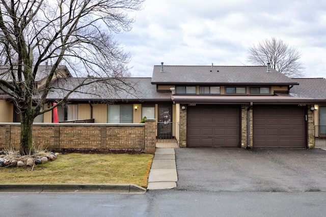 view of front facade with a garage, driveway, and a fenced front yard