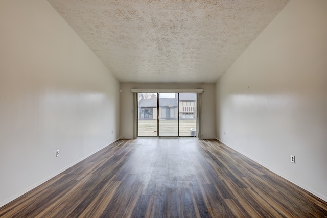 empty room with dark wood-style floors, a textured ceiling, and baseboards