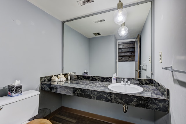 bathroom with a sink, visible vents, and toilet