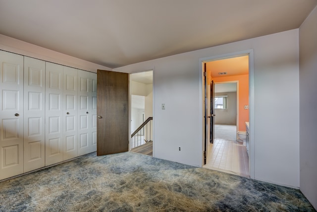 unfurnished bedroom with a closet and carpet floors