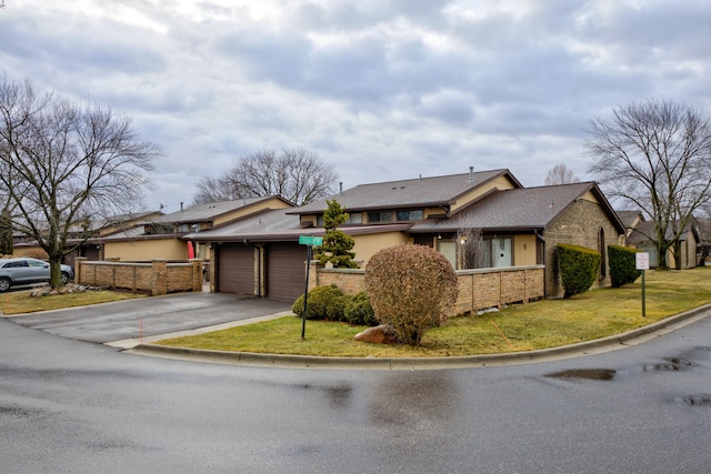 mid-century home with aphalt driveway, brick siding, and a garage