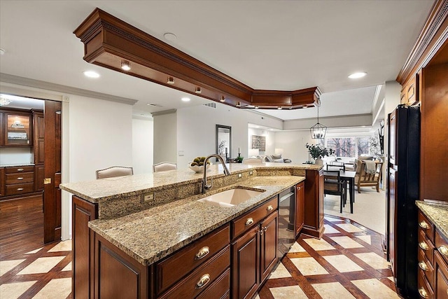 kitchen with a center island with sink, recessed lighting, freestanding refrigerator, open floor plan, and a sink